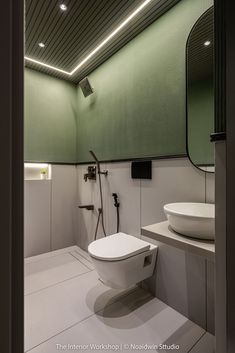 a white toilet sitting inside of a bathroom next to a sink