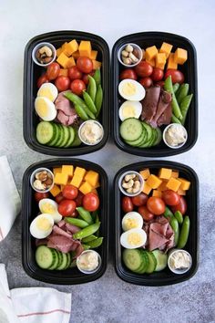 four plastic trays with different types of food in them on top of a table