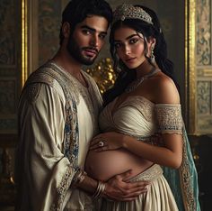 a man and woman dressed in medieval clothing pose for a photo while holding their pregnant belly