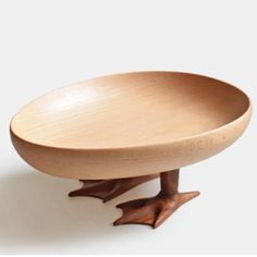 a wooden bowl with two legs on it