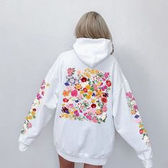 Elevate your style with this delightful and vibrant hoodie featuring a stunning wildflower design on the back and sleeves. Each hooded sweatshirt is carefully crafted to infuse a touch of nature into your wardrobe. The colorful wildflowers burst with life, creating a sense of warmth and joy. This hoodie is a perfect blend of style and comfort, making it an ideal addition to your wardrobe. Whether you're going for a walk in the park, a cozy evening in, or simply want to express your love for wildflowers, this hoodie has got you covered. Treat yourself or surprise a nature enthusiast in your life with this beautiful hooded sweatshirt. Don't wait - embrace the wildflower beauty today! 🌸 ✔️ Unique and eye-catching wildflower design ✔️ Soft and comfortable fabric for all-day coziness ✔️ Availa Spring White Hooded Sweatshirt, White Hooded Spring Sweatshirt, White Hooded Sweatshirt For Spring, White Floral Print Sweatshirt For Fall, Long Sleeve Floral Print Hoodie For Fall, Spring Graphic Print Hoodie Sweatshirt, Multicolor Spring Hoodie With Drawstring Hood, Multicolor Hoodie For Spring, Multicolor Hoodie With Drawstring For Spring