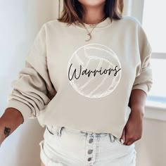 a woman wearing a sweatshirt with the word warriors printed on it