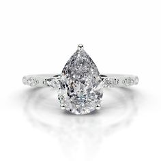 a pear shaped diamond engagement ring on a white background