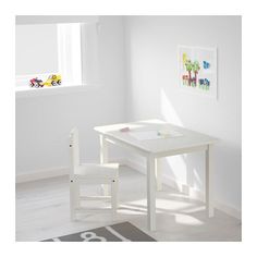 a small white table and chair set in a child's room with a window