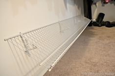 an empty closet with clothes hanging on the wall and a shoe rack next to it