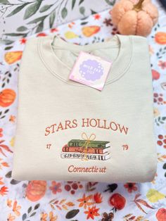 a white t - shirt with the words stars hollow on it and a teddy bear next to it