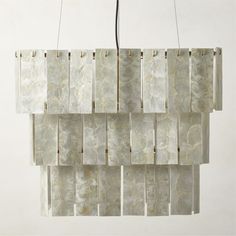 a chandelier hanging from the ceiling made out of marble tiles