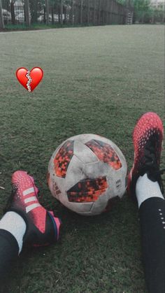 a person laying on the ground with a soccer ball in front of their feet and a heart above them