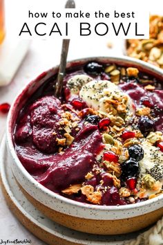 a bowl filled with fruit and granola on top of a table next to other foods