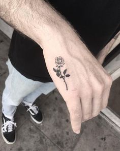 a man's hand with a rose tattoo on it