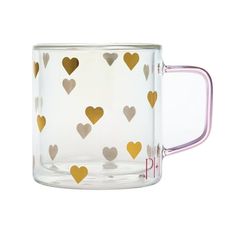 a clear glass mug with gold hearts on the outside and inside, sitting in front of a white background