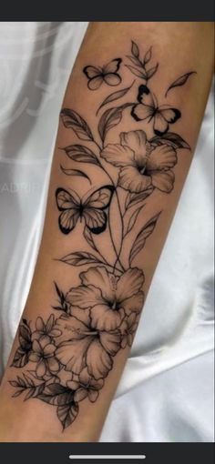 a woman's arm with flowers and butterflies on it