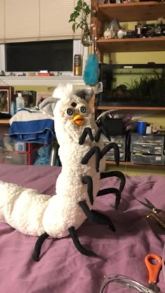 a stuffed animal sitting on top of a bed next to scissors and other items in a room