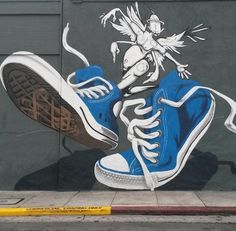 a blue sneaker has been painted on the side of a building with an image of a bird flying over it