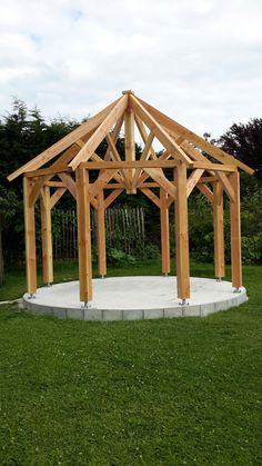 a wooden structure sitting on top of a lush green field