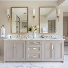 a bathroom with double sinks and two mirrors on the wall next to eachother