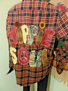 a plaid jacket with patches and letters on it