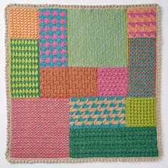 a multicolored crocheted square is displayed on a white surface