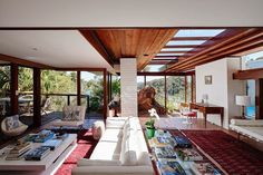 a living room with couches, tables and windows overlooking the mountains in the distance