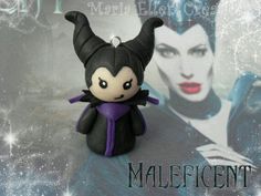 an evil queen doll sitting next to a maleficent sign with snowflakes on it