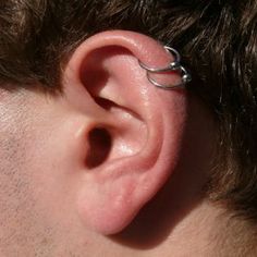 a close up of a person's ear with a nose ring attached to it