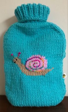 a blue knitted hat with a snail on it