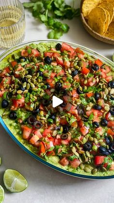 a platter filled with guacamole, black olives, and cilantro