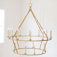 a chandelier with candles hanging from it's sides in a white room