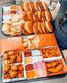 two trays filled with chicken and waffle fries next to each other on a table