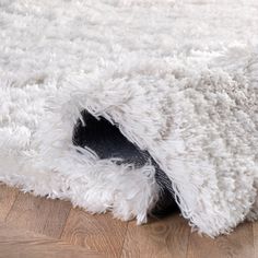 a white rug on the floor with wood floors