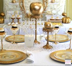 a table topped with lots of gold and white plates