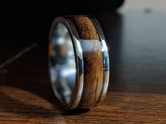 a wooden ring with silver inlays on a table