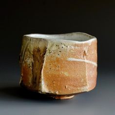 a white and brown vase sitting on top of a table