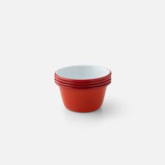 four red and white bowls stacked on top of each other in front of a white background