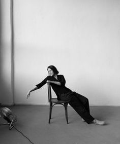 a black and white photo of a woman sitting in a chair