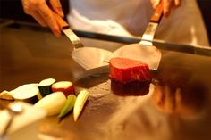 a person cutting up some food on top of a table