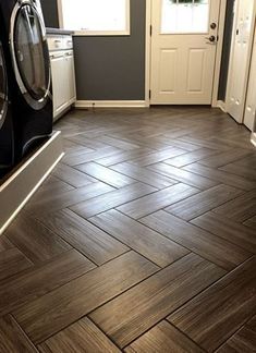 a kitchen with wood flooring and white appliances in it's center, next to a washer and dryer