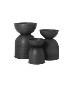 three black vases sitting next to each other on top of a white background,