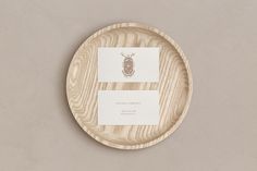 a wooden plate with a business card on the front and back side, sitting on a gray surface