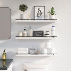 a white bathroom with shelves holding personal care items and a mirror above the toilet bowl