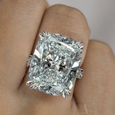 a close up of a person's hand with a diamond ring