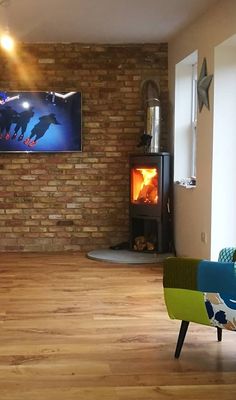 a living room filled with furniture and a flat screen tv mounted on the wall above a fire place