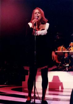 a woman standing on top of a stage holding a microphone