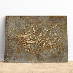 a metal plaque with arabic writing on it in the middle of a wood flooring area