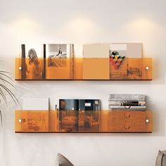 there are two shelves with pictures on them in the living room, one is yellow and the other is orange