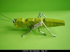 a close up of a toy insect on a green surface