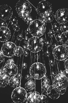 a chandelier with many balls hanging from it's sides and lights in the middle