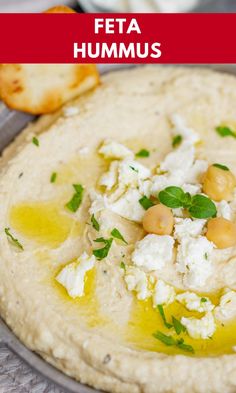 a pita with hummus, olives and feta cheese on the side