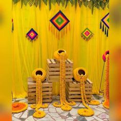 some yellow decorations are set up in front of a curtain and wooden pallets on the floor