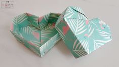 two origami boxes with flamingos and palm leaves on them, one opened to show the inside